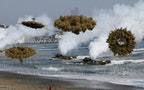 Amphibious assault vehicles of the South Korean Marine Corps throw smoke bombs as they move to land on shore during a U.S.-South Korea joint landing operation drill in Pohang