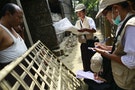 Volunteers speak to family during national census at Rohingya village in Sittwe