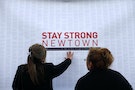 A woman touches a printout of messages from teenagers around the United States at a memorial for the victims of the Sandy Hook Elementary School shooting in Newtown