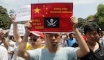 Protesters hold anti-China placards while marching in an anti-China protest on a street in Hanoi