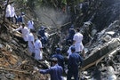 Rescue workers search an air force plane crash site near Nadee village, in Xiang Khouang province