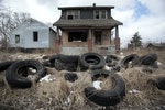 Ilegally dumped tires sit in front of a vacant, blighted home in a once thriving neighborhood on the east side of Detroit