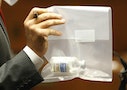 Deputy district attorney David Walgren holds a bottle of propofol found at Michael Jackson's residence during Dr.Conrad Murray's trial in the death of Jackson in Los Angeles