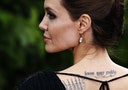 Actress Angelina Jolie displays her tattoo as she arrives for a special Maleficent Costume Display at Kensington Palace in London