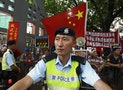 A policeman stands in front of a group supporting China's recent white paper over the control of Hong Kong, during a mass protest demanding universal suffrage in Hong Kong