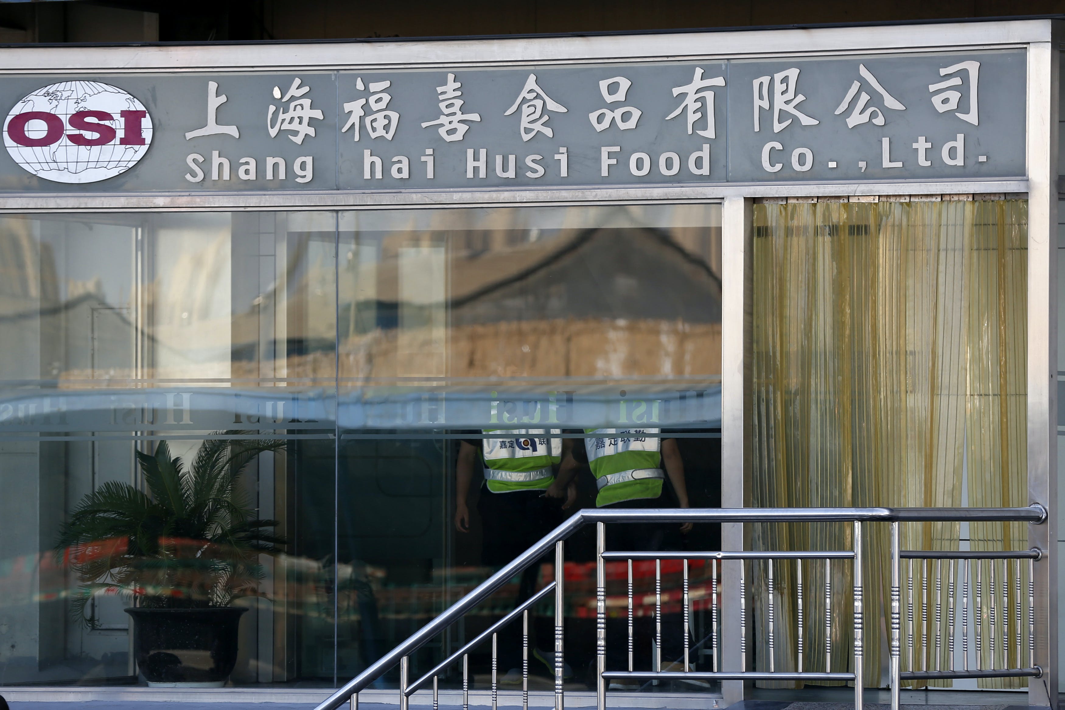 Security guards stand inside the Husi Food factory in Shanghai