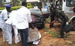 Workers pick items at the scene of a bombing in Kaduna