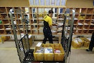 A postwoman of Deutsche Post sorts mail at a sorting office in Berlin