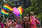 Participants wave rainbow flags as they dance on their boat during the 19th Amsterdam Canal Parade in Amsterdam