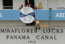 Workers adjust a sign ahead of the celebration of the 100th anniversary of the Panama Canal at the Panama Canal, in Panama City
