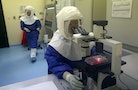 Doctors work in a Biosafety Level III laboratory on samples of virus at the National Institute of Health in Lima