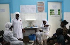 Nurses talk near a poster displaying a government message against Ebola, at a maternity hospital in Abidjan