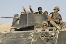Lebanese army soldiers gesture while riding on an armoured vehicle as they exit the Sunni Muslim border town of Arsal, in eastern Bekaa Valley