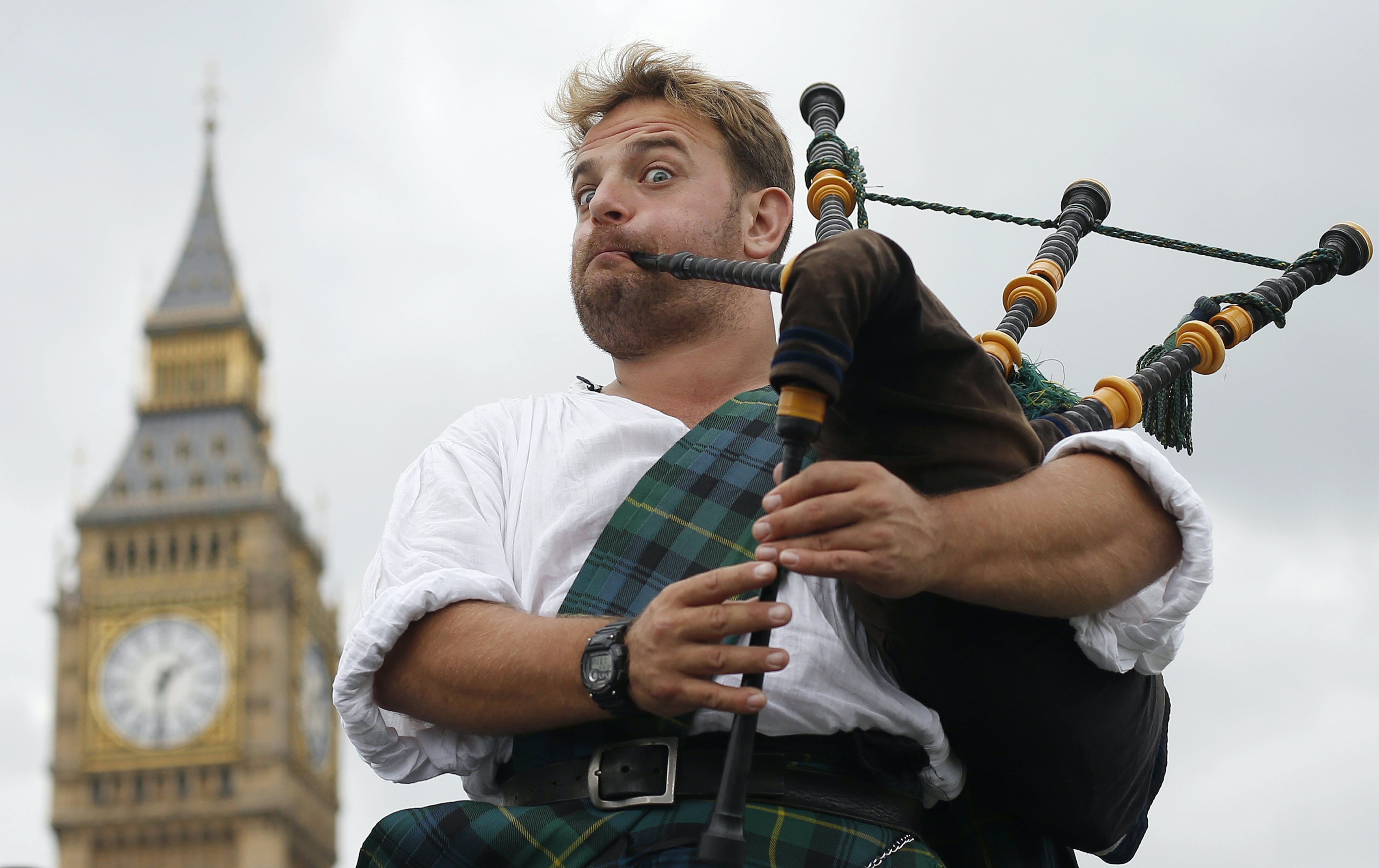 Bagpiper and busker David Whitney of Aberdeen, Scotland, plays the bagpipes near Big Ben and the Houses of Parliament in central London