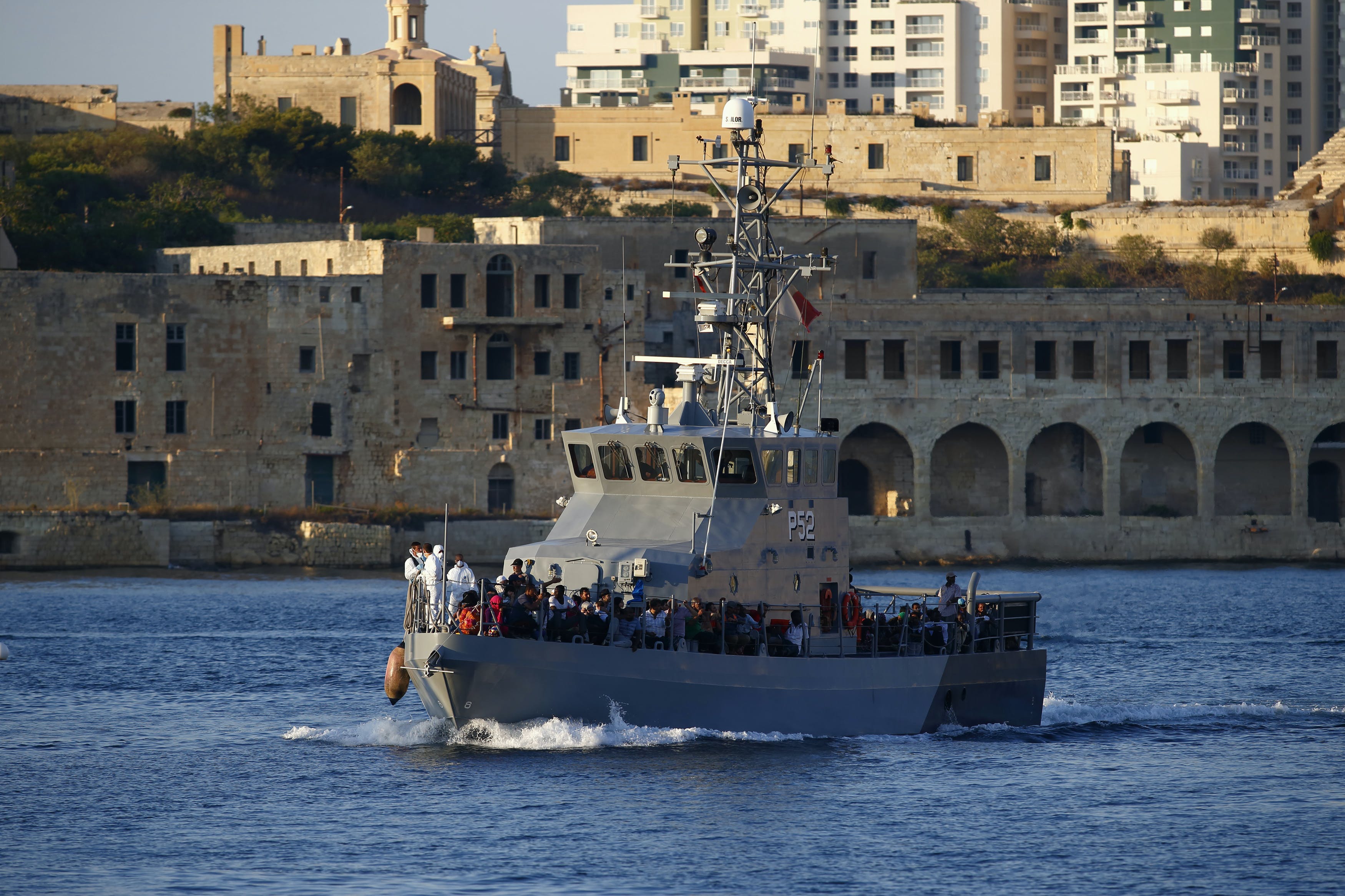 An Armed Forces of Malta patrol boat carrying rescued migrants approaches the AFM's Maritime Squadron base at Haywharf in Valletta's Marsamxett Harbour