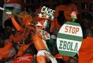 A fan of Ivory coast holds a sign with a message against Ebola during the 2015 African Nations Cup qualifying soccer match between Ivory Coast and Sierra Leone in Abidjan