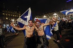 Yes campaign supporters wave Scottish Saltire flags in central Glasgow