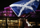 A supporter from the "Yes" Campaign waves a Scottish Saltire flag outside the Scottish Parliament in Edinburgh, Scotland