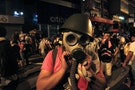 Protester puts on a gas mask to prepare for a possible tear gas attack as hundreds of protesters block a main road at Hong Kong's shopping Mongkok district