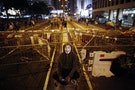 A protester sits in front of a barricade on the main street to the financial Central district in Hong Kong