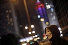 A protester wears a Guy Fawkes mask next to a barricade on a main street leading to the financial Central district in Hong Kong
