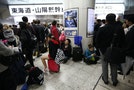 Passengers wait for resumption of bullet train services after they were suspended due to strong winds and heavy rain caused by Typhoon Phanfone, at Tokyo Station in Tokyo