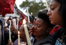 A woman wipes away tears during a candlelight vigil in St. Louis