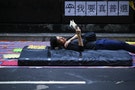 A pro-democracy protester reads while resting on an improvised bed in an area protesters are occupying in Mongkok shopping district in Hong Kong