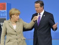 Britain's Prime Minister David Cameron greets German Chancellor Angela Merkel at the start of the NATO summit at the Celtic Manor resort, near Newport