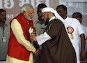 Narendra Modi receives flowers from a Muslim cleric after inauguration of a hospital in Balasinore