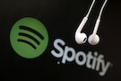 Headphones are seen in front of a logo of online music streaming service Spotify in this illustration picture