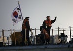 South Korean coastguard officers operate on vessel at site where capsized passenger ship Sewol sank in Jindo