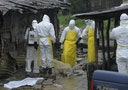 Health workers wearing protective clothing prepare to carry an abandoned dead body presenting with Ebola symptoms at Duwala market in Monrovia