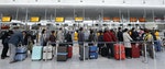 Passengers await their check-in for German airline Lufthansa at Munich airport