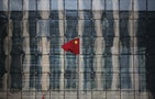 Chinese national flag flutters at the headquarters of a commercial bank on a financial street near the headquarters of the People's Bank of China, China's central bank, in central Beijing