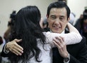 Taiwan President Ma Ying-jeou hugs a Kuomintang (KMT) party official after announcing his resignation from the party's chairman position, during their central standing committee in Taipei