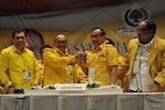 Aburizal Bakrie, the head of Golkar Party, shakes hands with Akbar Tandjung, advisory council head of the Golkar party, after being re-elected as the head of the party in Nusa Dua