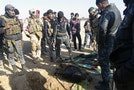 Iraqi security forces look at the body of a dead member of the Islamic State who died in clashes with Iraqi security forces on the outskirt of Ramadi
