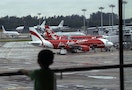 A child looks on at a viewing gallery overlooking AirAsia planes on the tarmac at Changi Airport in Singapore