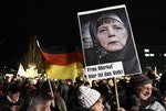 PEGIDA的示威民眾手持德國總理梅克爾包上頭巾的海報，在德勒斯登（Dresden）的遊行中。Photo Credit: AP/達志影像 