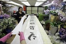 Workers prepare a banner for upcoming funeral of Nina Wang in Hong Kong