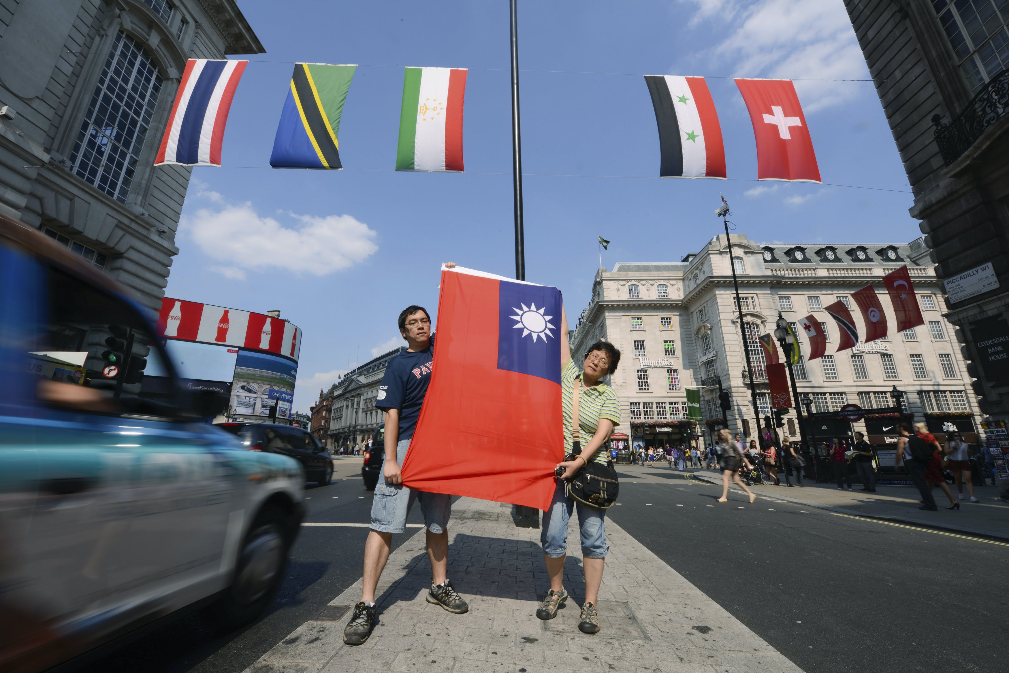 Two Taiwanese citizens hold up the flag of Taiwan at the retail district of Lower Regents Street in London