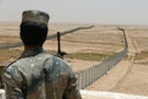 Member of the Saudi border guards force stands guard next to a fence on Saudi Arabia's northern borderline with Iraq