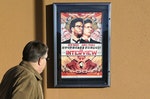 A man walks by poster for film "The Interview" outside Alamo Drafthouse theater in Littleton