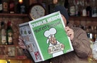 A man poses with the new issue of French satirical weekly Charlie Hebdo at a cafe in Nice