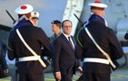 French President Francois Hollande reviews the troops during his visit aboard the French nuclear aircraft carrier Charles de Gaulle to present his New Year wishes to the French military forces