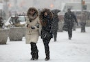 People walk through heavy falling snow in Times Square in New York