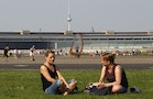 People enjoy a sunny day at tarmac of former Tempelhof airport in Berlin