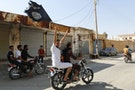 Resident of Tabqa city touring the streets on a motorcycle waves Islamist flag in celebration after Islamic State militants took over Tabqa air base, in nearby Raqqa city