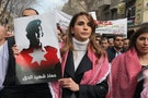 Jordan's Queen Rania holds a picture of recently executed Jordanian pilot Muath in Amman